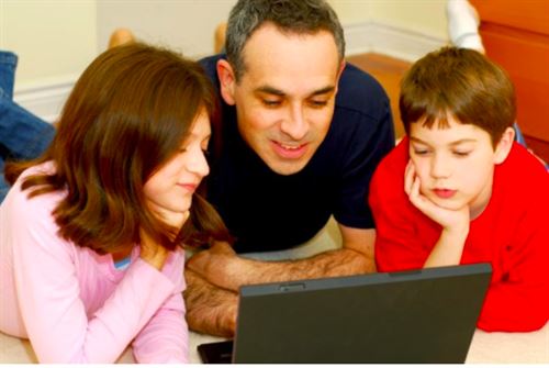 parents and boy looking at their laptop